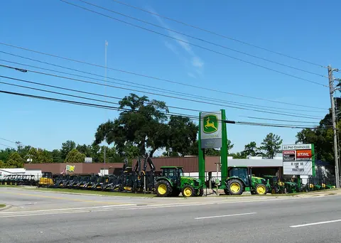 Tractors and agricultural equipment displayed at a dealership.