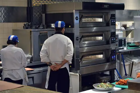 Staff and cooking equipment inside a commercial kitchen.