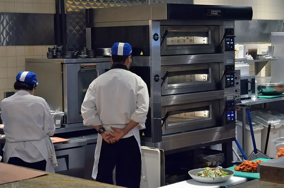 Staff and cooking equipment inside a commercial kitchen.