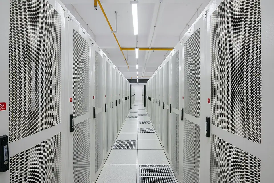 An aisle of equipment racks in a data center.